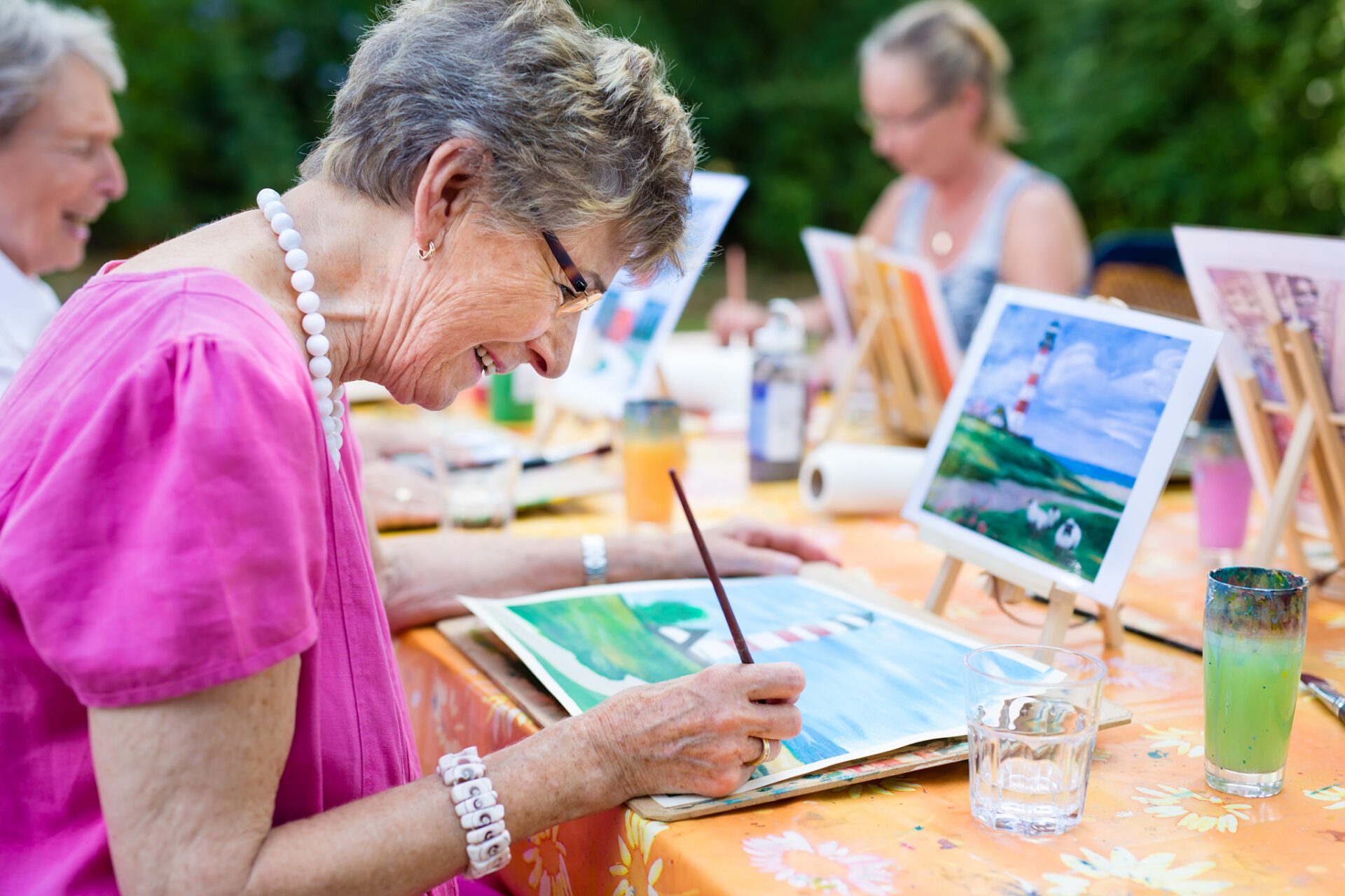 senior woman smiling while drawing with the group.