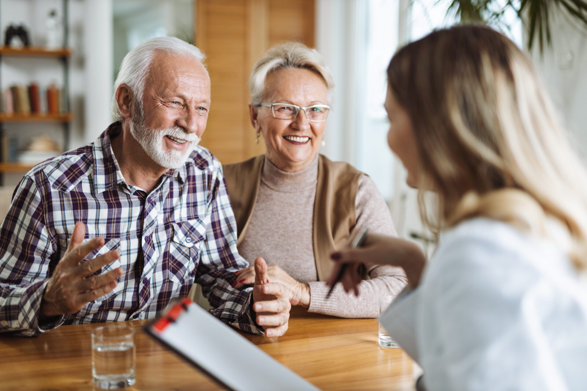 mature couple talking to a caregiver at home